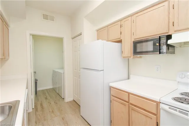 a view of a kitchen with a sink and wooden floor