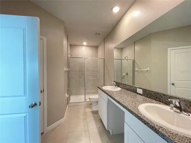 a spacious bathroom with a granite countertop sink mirror and shower