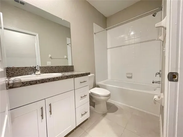 a bathroom with a granite countertop sink a toilet and a bathtub