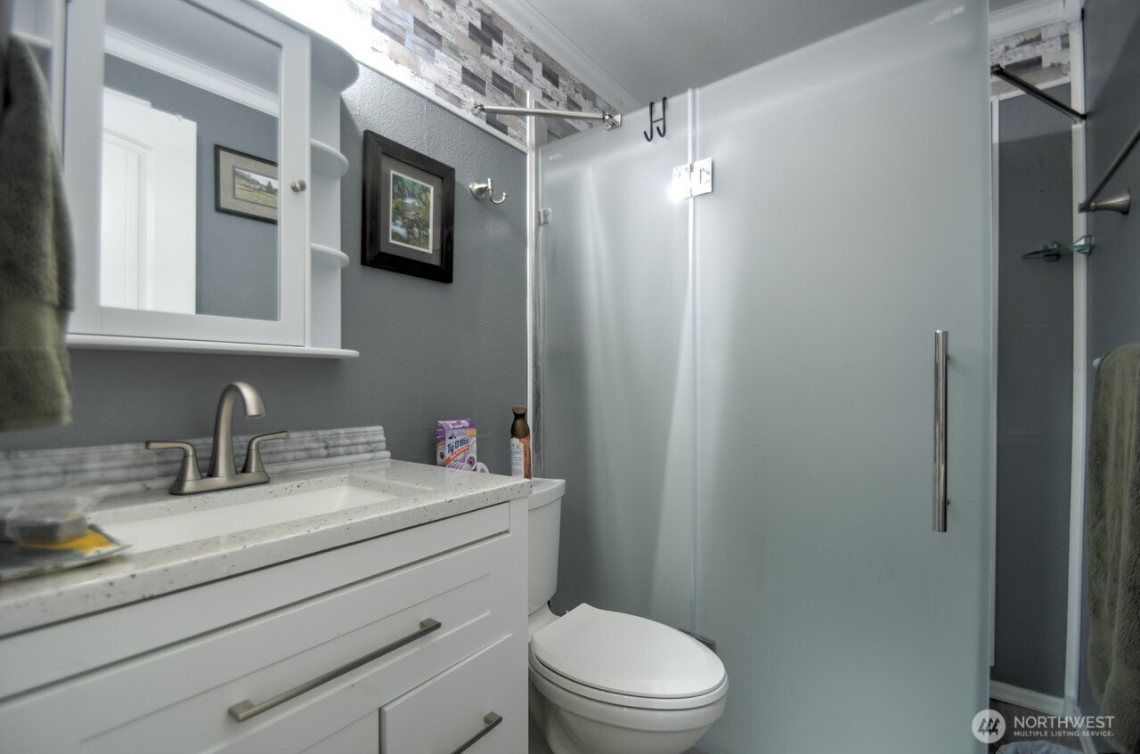 5922 184th Lane Southwest Rochester, WA 98579 - Photo 11 of 34 a bathroom with a granite countertop sink mirror vanity and toilet