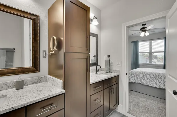 a en suite bathroom with a granite countertop sink and a mirror