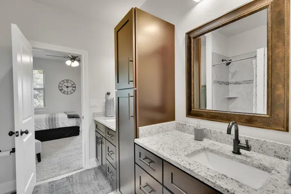 a bathroom with a granite countertop sink and a mirror