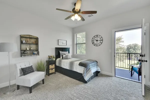 a spacious bedroom with a bed a couch and a window