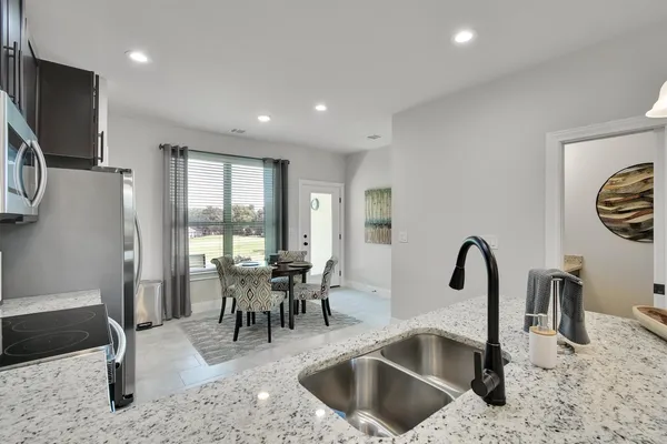 a kitchen with a kitchen island a sink cabinets and stainless steel appliances