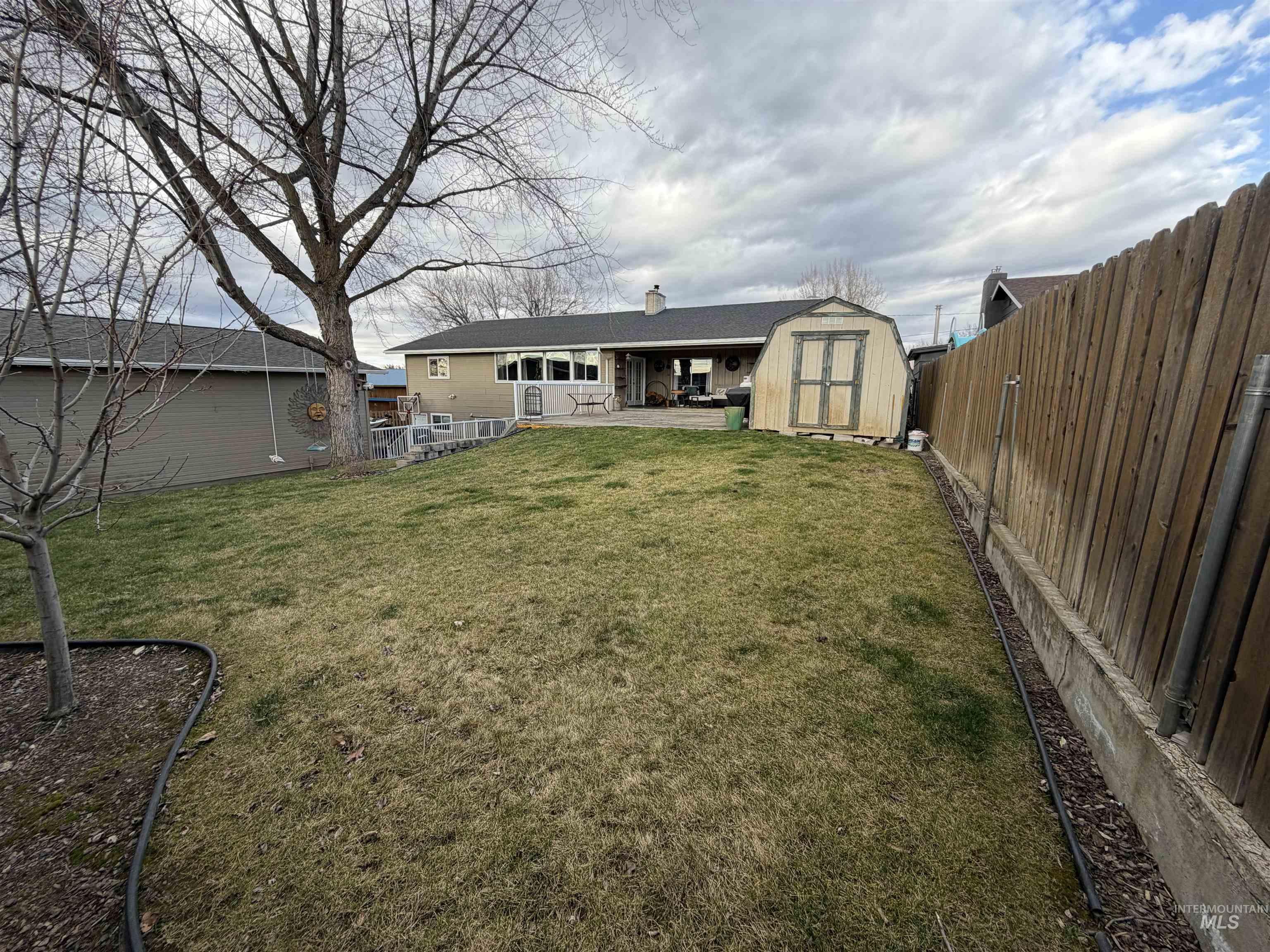 1306 Hemlock Avenue Lewiston, ID 83501 - Photo 30 of 38 Rear view of house with a storage unit, a patio, a chimney, and a fenced backyard