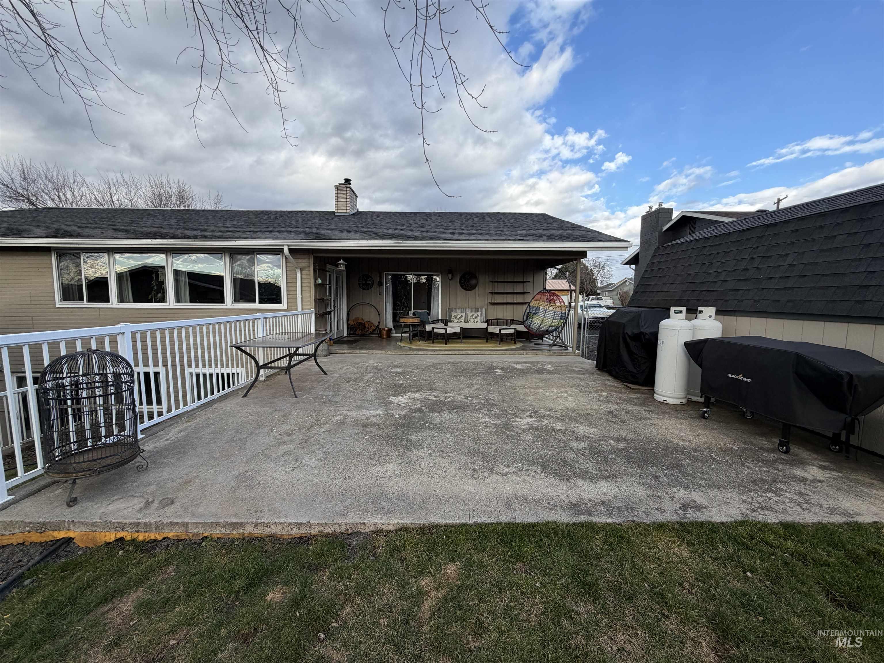 1306 Hemlock Avenue Lewiston, ID 83501 - Photo 31 of 38 Back of house featuring a shingled roof, a chimney, and a patio