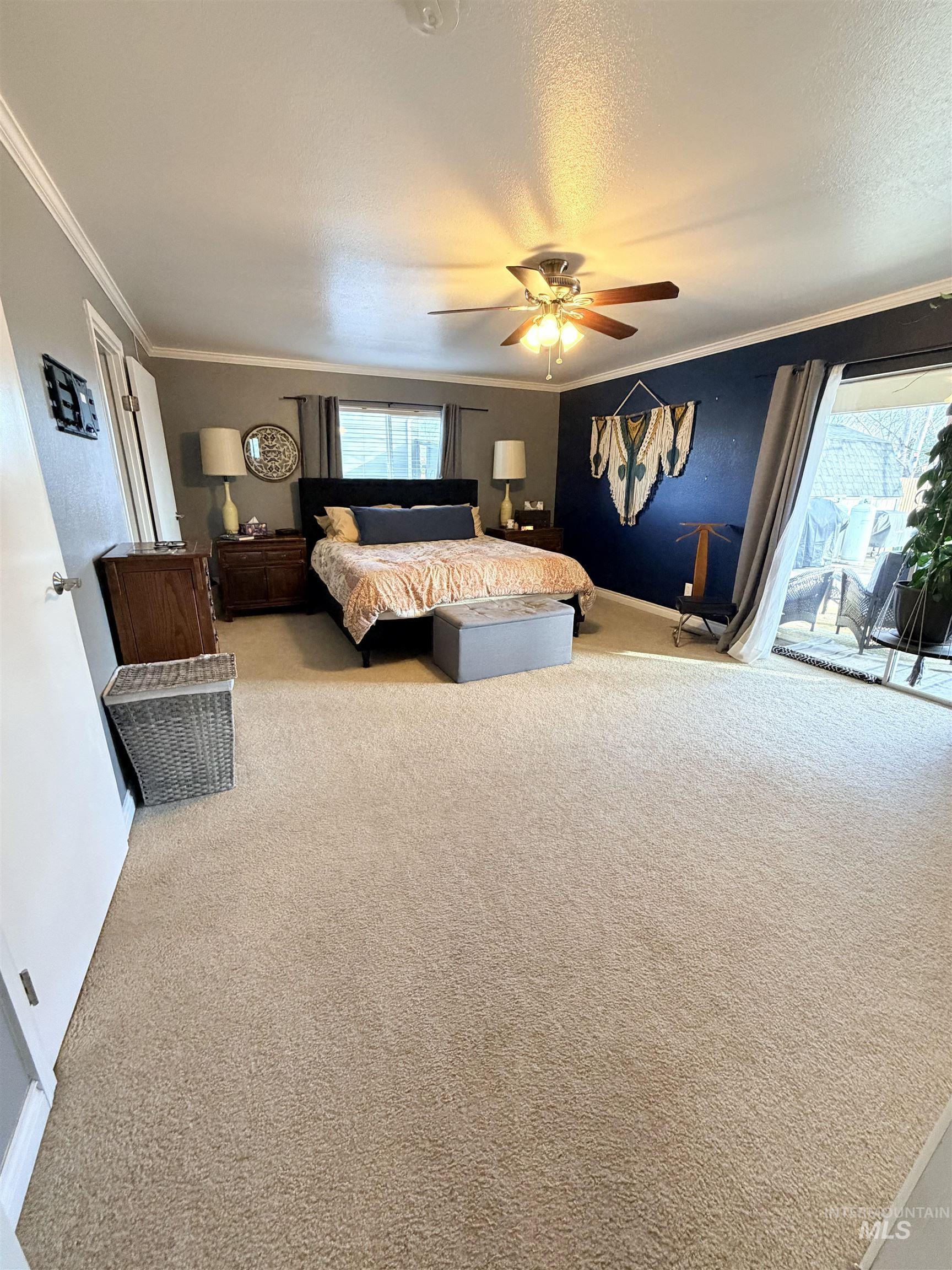 1306 Hemlock Avenue Lewiston, ID 83501 - Photo 10 of 38 Bedroom featuring access to exterior, crown molding, light carpet, a ceiling fan, and a textured ceiling