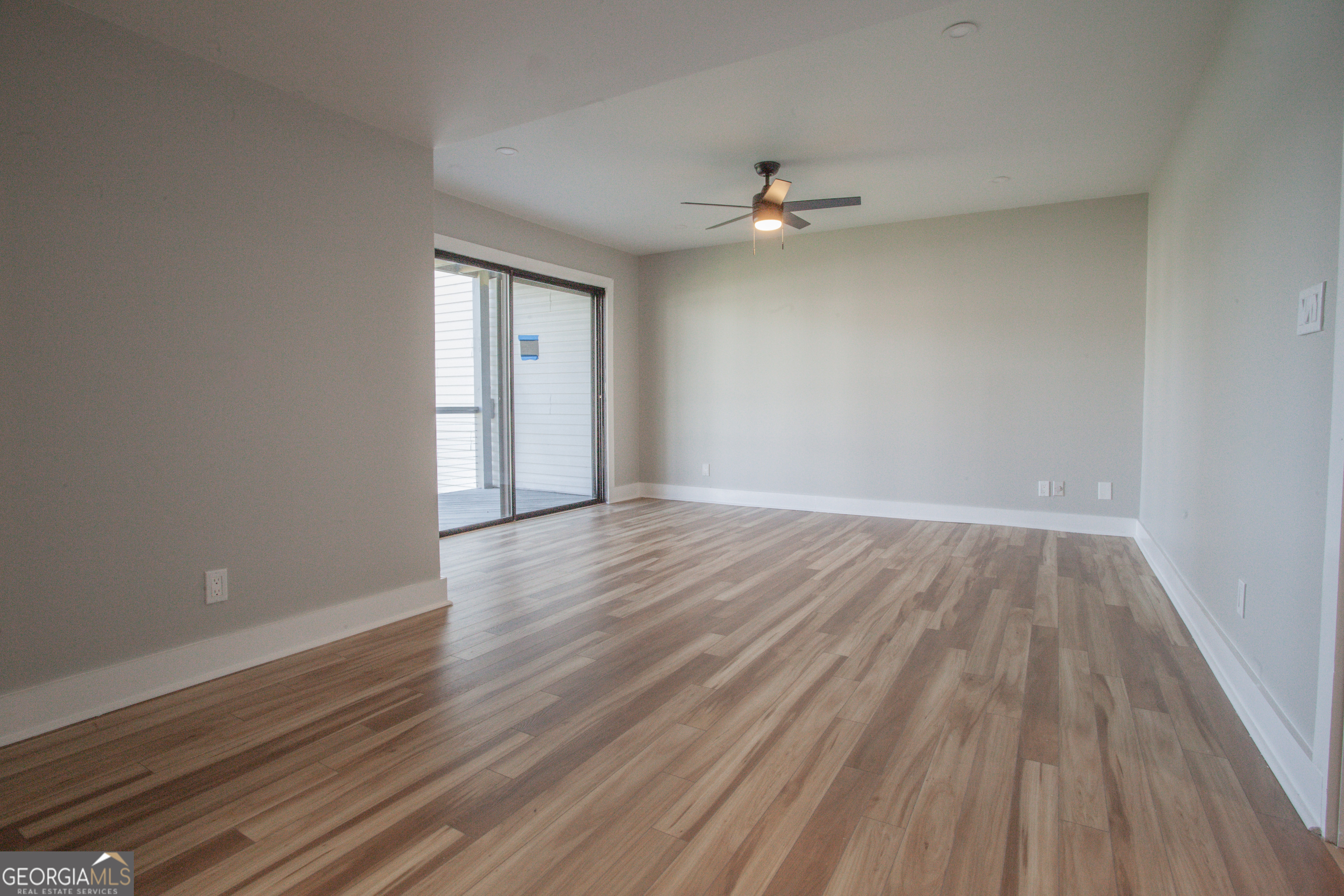 295 Clearview Court Villa Rica, GA 30180 - Photo 14 of 49 a view of an empty room with wooden floor and a ceiling fan