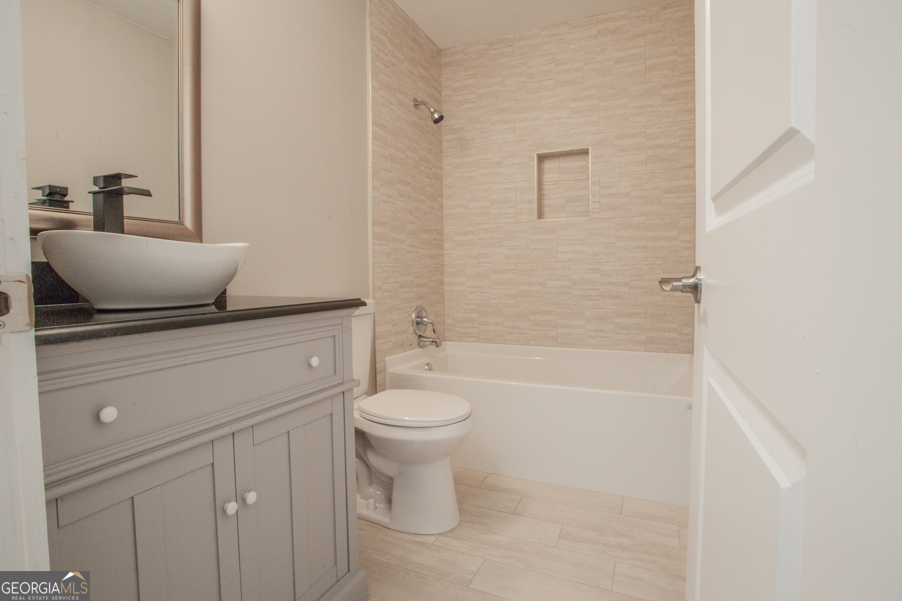 295 Clearview Court Villa Rica, GA 30180 - Photo 8 of 49 a bathroom with a granite countertop toilet a sink and bathtub