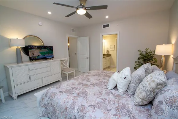 a bedroom with a large bed and a chandelier