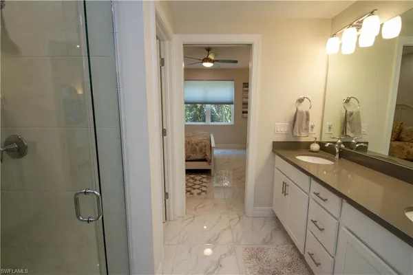 a en suite bathroom with a granite countertop sink a toilet and a mirror