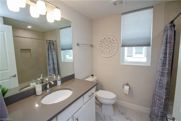a bathroom with a toilet a sink a mirror and vanity