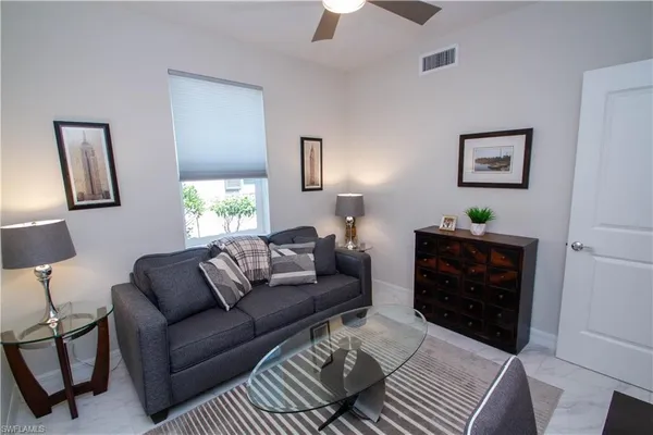 a living room with furniture a lamp and a window