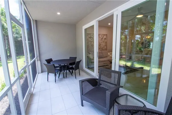 a dining room with furniture and a floor to ceiling window