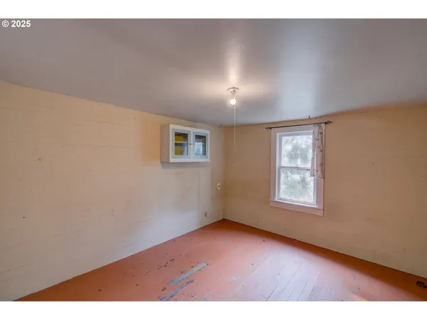 a view of an empty room and wooden floor