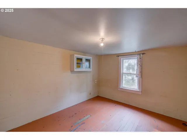 a view of an empty room and wooden floor