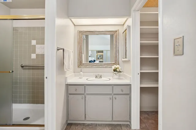 a bathroom with a sink a mirror a vanity and a shower