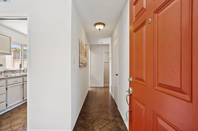 a view of a hallway with wooden floor and staircase