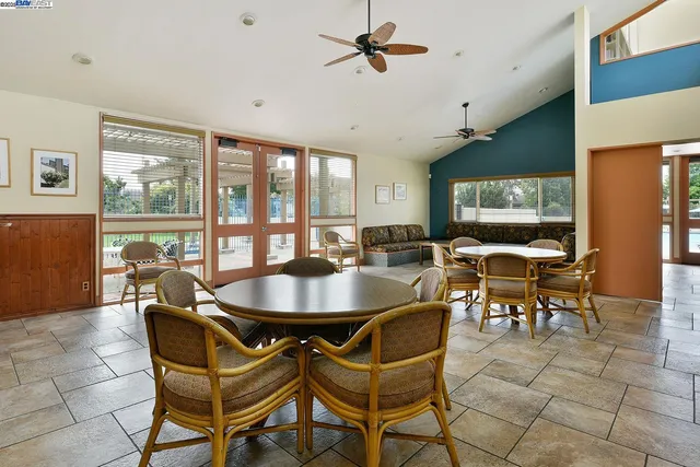 a dining room with furniture and a large window