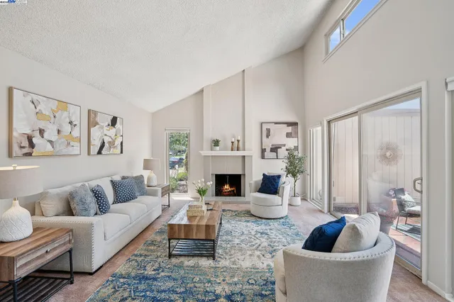 a living room with furniture a fireplace and a painting