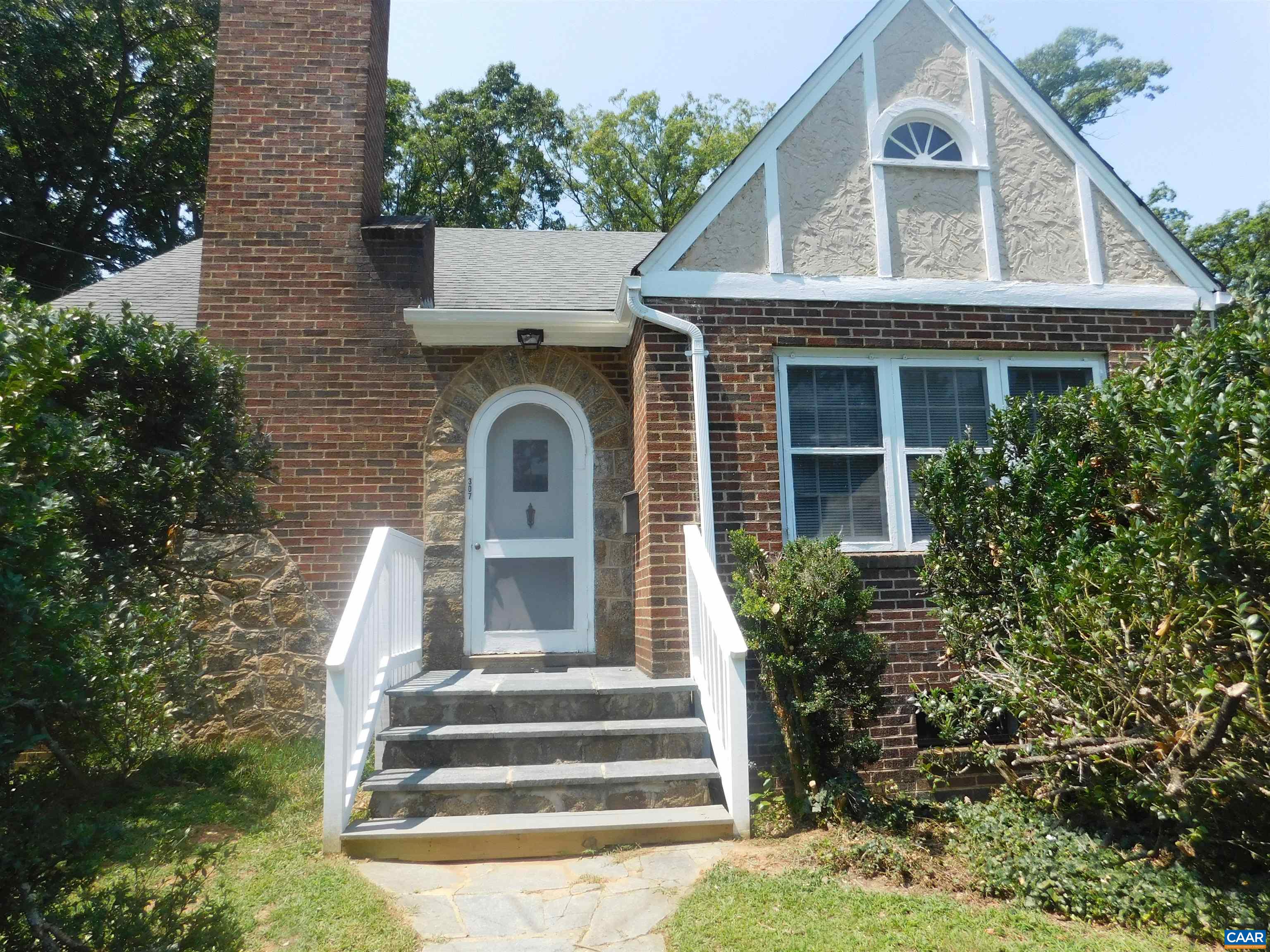 a front view of a house with plants