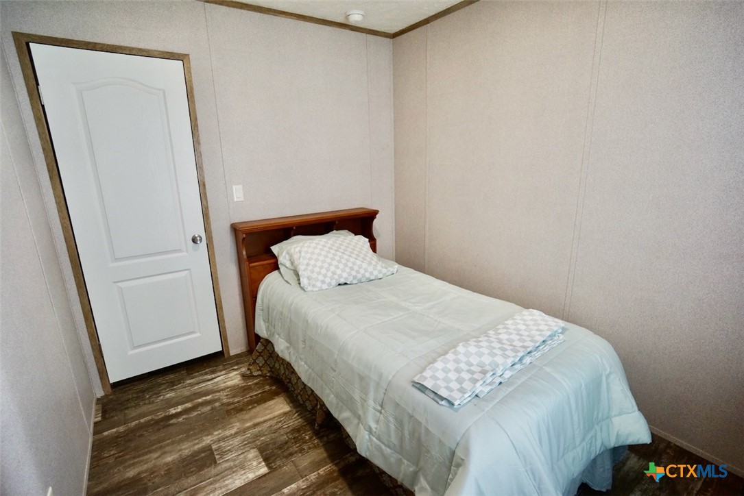 1502 West Monroe Avenue Port O'Connor, TX 77982 - Photo 15 of 22 a bedroom with a bed and hardwood floor