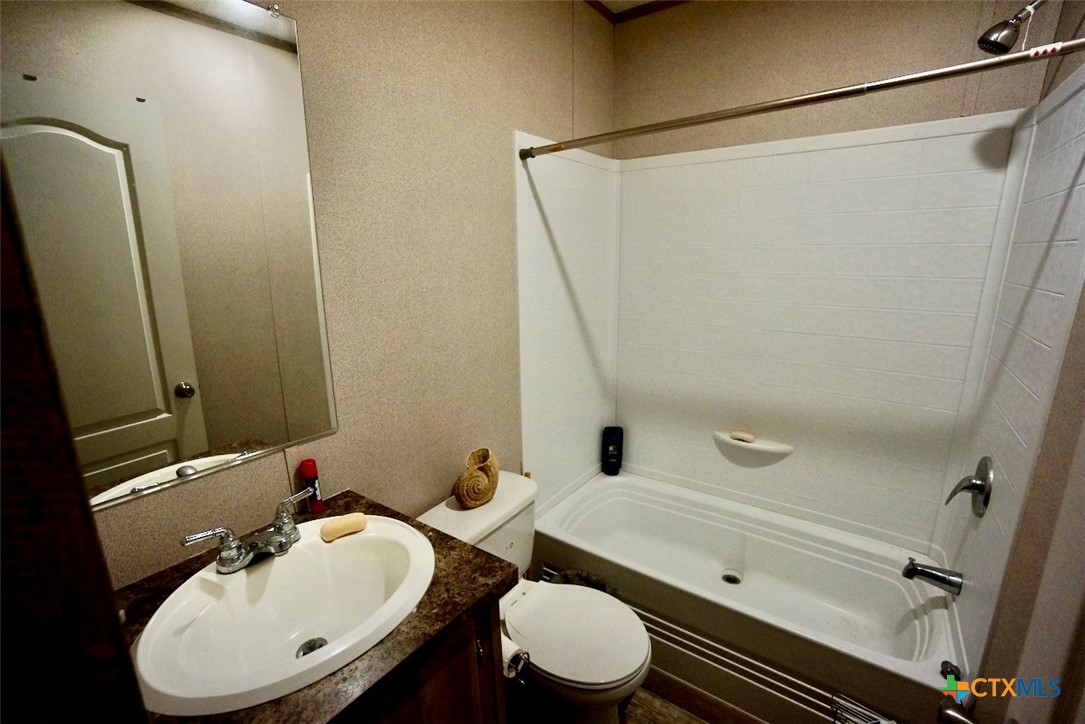 1502 West Monroe Avenue Port O'Connor, TX 77982 - Photo 16 of 22 a bathroom with a sink a toilet and a mirror