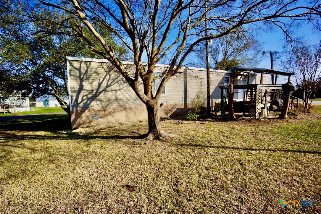 1502 West Monroe Avenue Port O'Connor, TX 77982 - Photo 6 of 22 a view of a yard with plants and trees