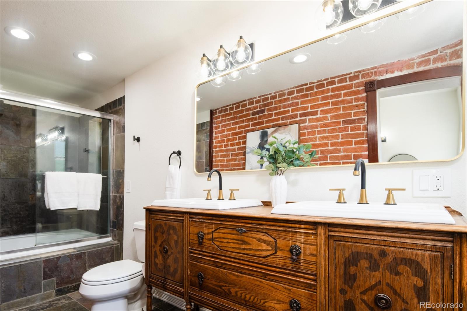 3519 L Newton Street Denver, CO 80211 - Photo 23 of 40 a bathroom with a sink a toilet and a large mirror