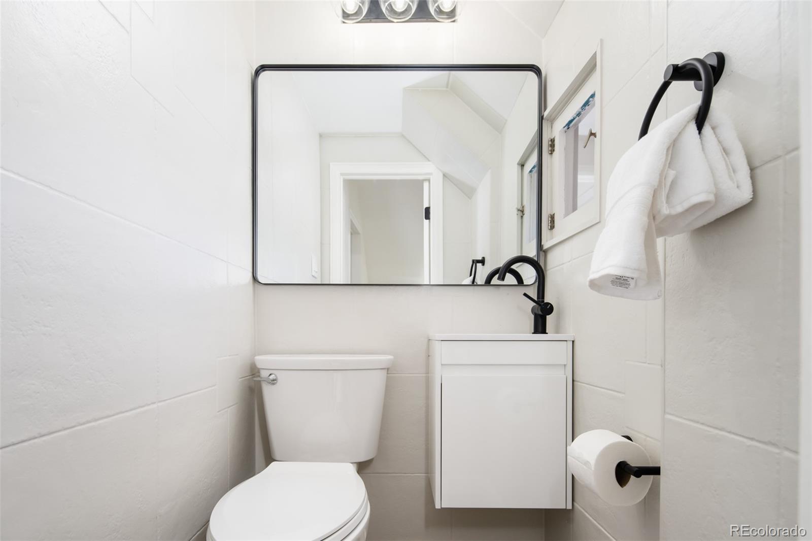 3519 L Newton Street Denver, CO 80211 - Photo 33 of 40 a bathroom with a toilet sink and mirror