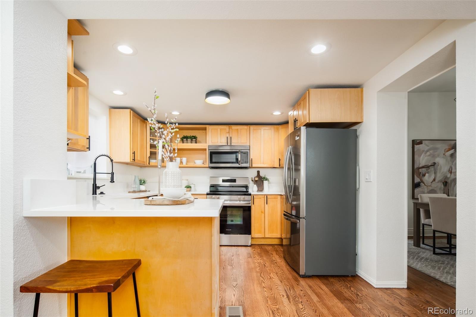3519 L Newton Street Denver, CO 80211 - Photo 5 of 40 a kitchen with stainless steel appliances granite countertop a refrigerator a sink dishwasher a stove with white cabinets and wooden floor