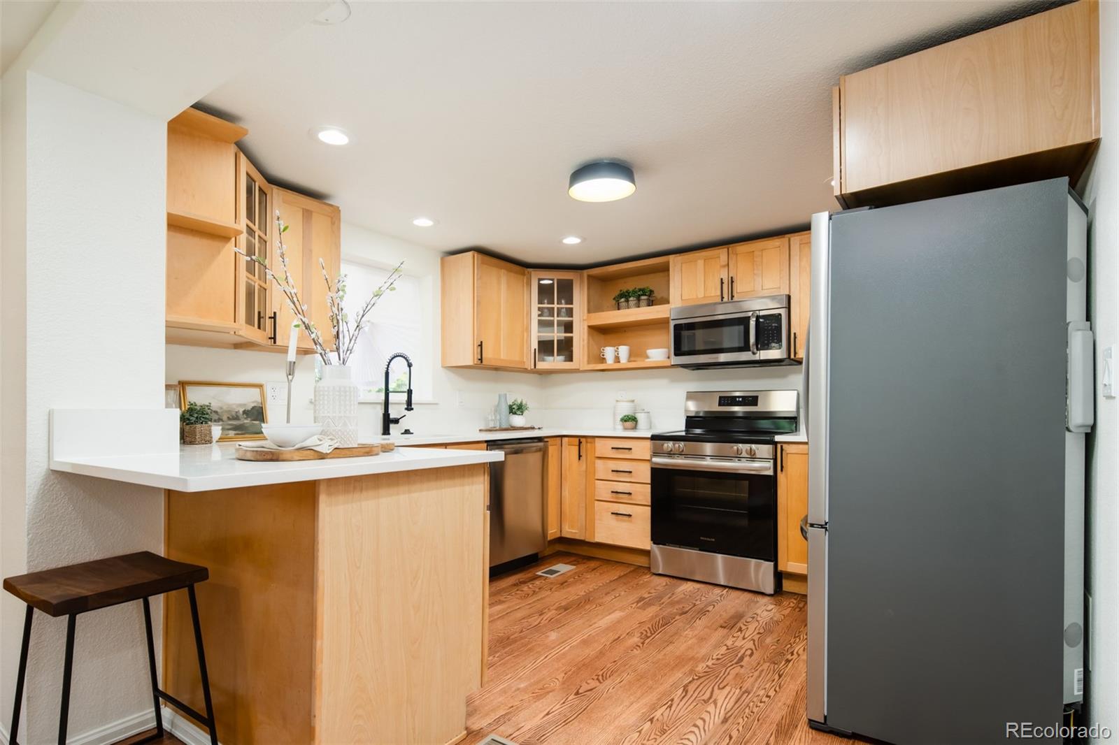 3519 L Newton Street Denver, CO 80211 - Photo 6 of 40 a kitchen with stainless steel appliances granite countertop a sink a stove a refrigerator cabinets and a dining table