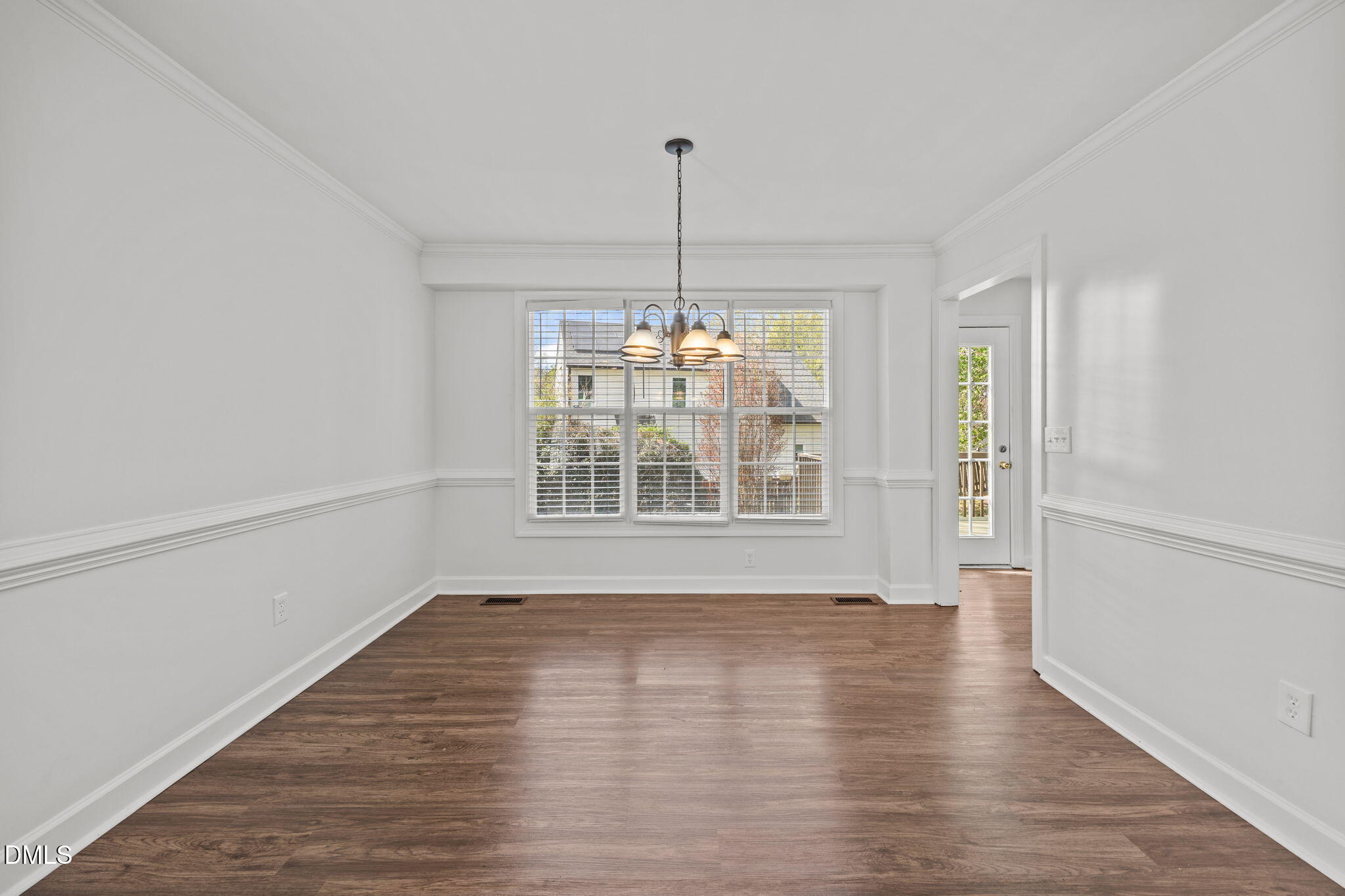 9220 Pennythorne Court Raleigh, NC 27615 - Photo 14 of 49 a view of an empty room with wooden floor and a window