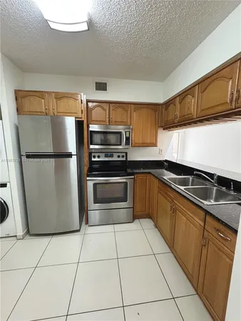 a kitchen with a refrigerator sink and microwave
