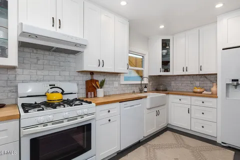 a kitchen with cabinets appliances a sink and a counter space