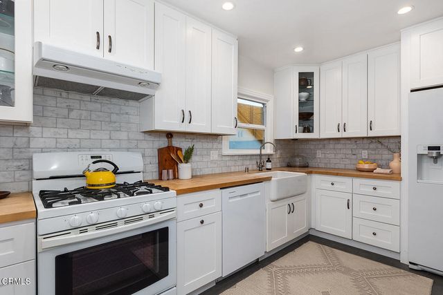 a kitchen with cabinets appliances a sink and a counter space