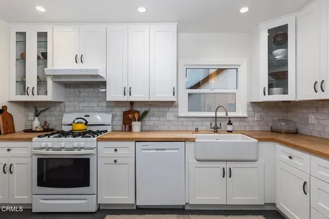 a kitchen with granite countertop white cabinets and appliances