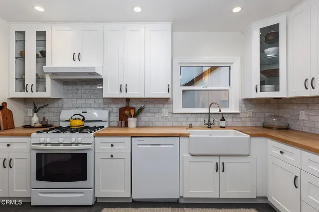 a kitchen with granite countertop white cabinets and appliances