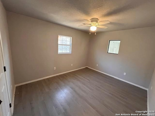 236 Hopi Bandera, TX 78003 - Photo 17 of 34 an empty room with wooden floor chandelier fan and windows