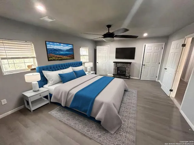 a spacious bedroom with a bed a couch and a flat screen tv