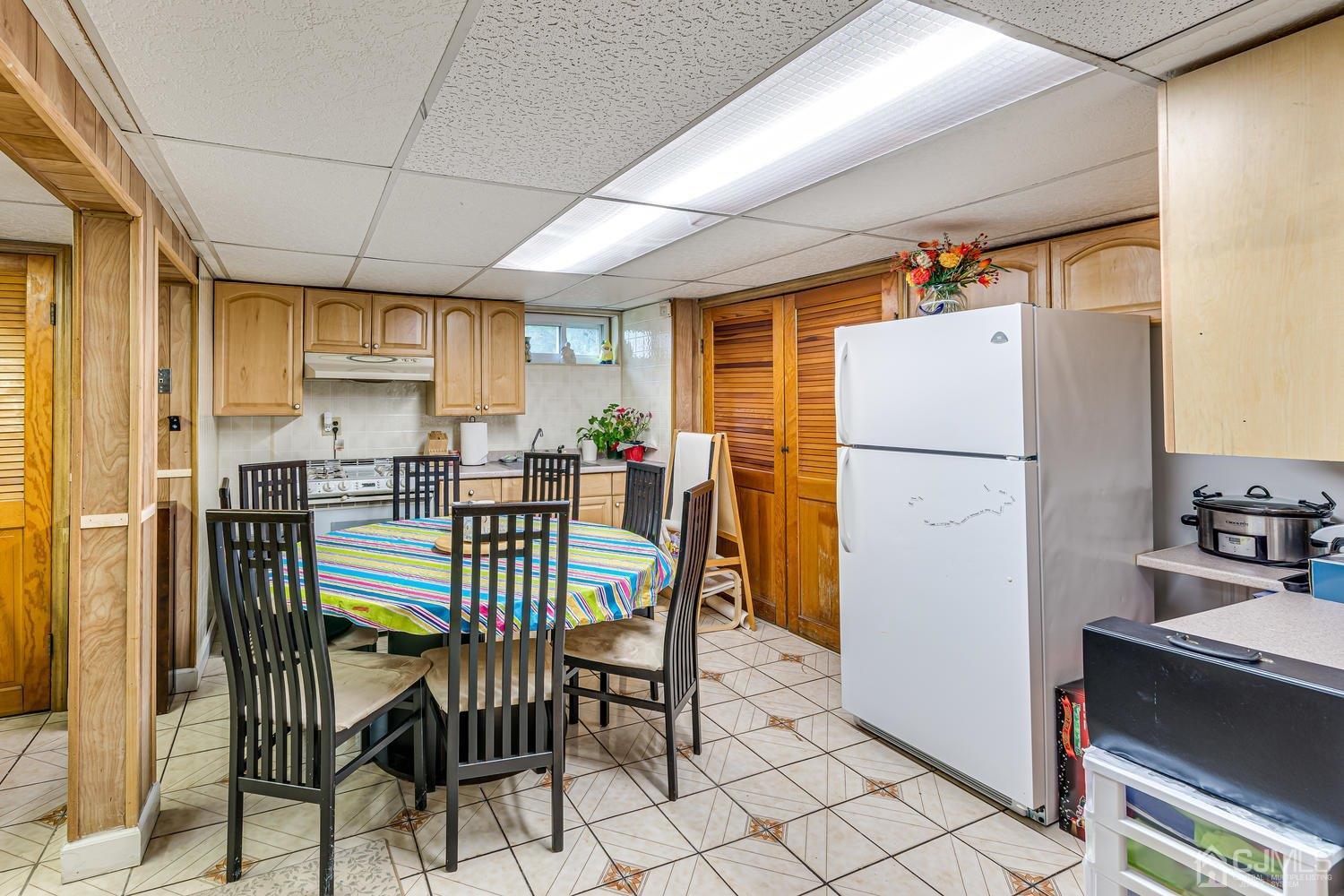 983 New Dover Road Edison, NJ 08820 - Photo 17 of 25 a kitchen with refrigerator cabinets dining table and chairs