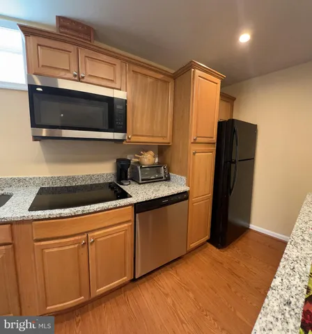 a kitchen with granite countertop a refrigerator stove and microwave