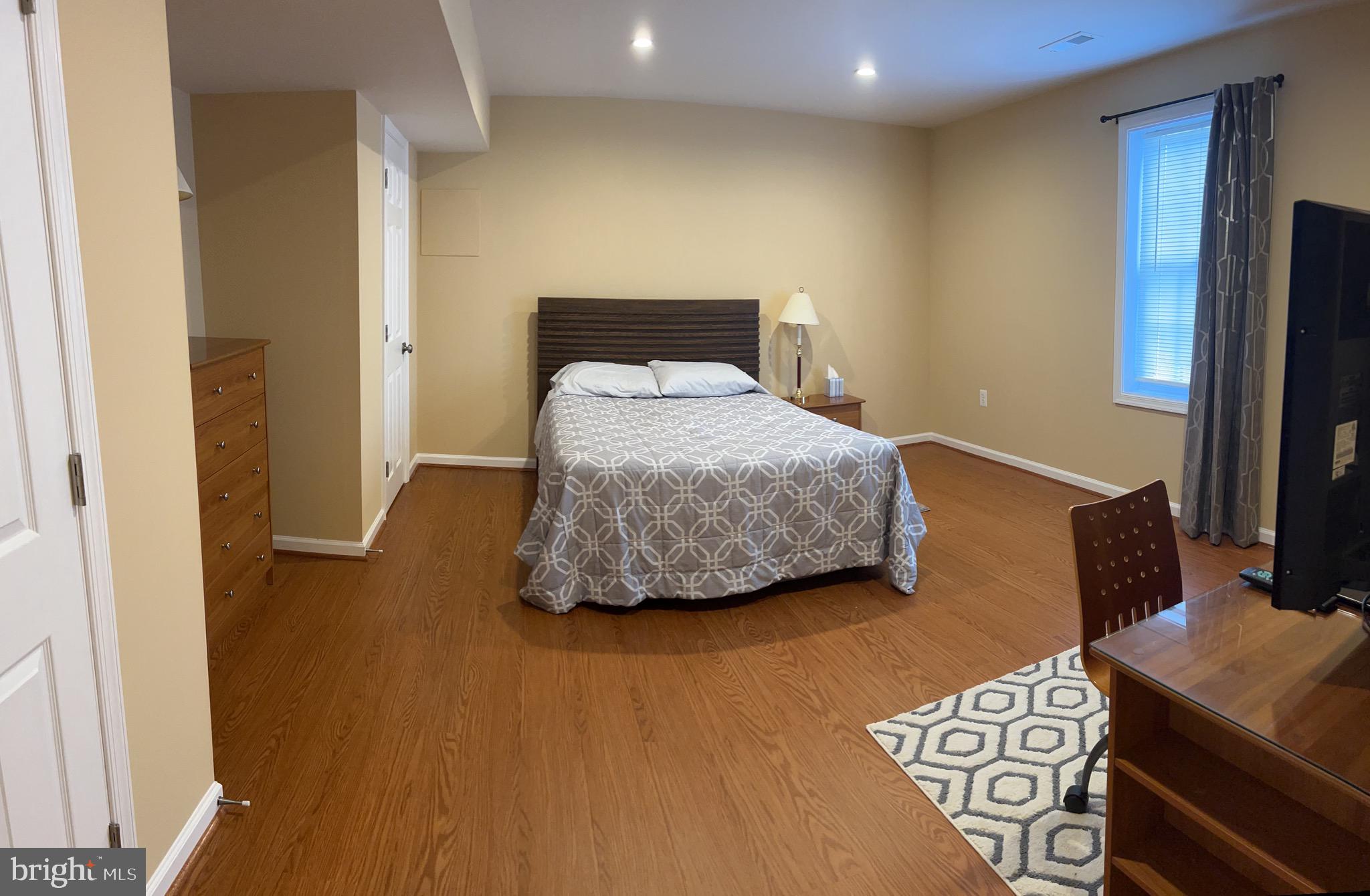 5802 Telluride Lane, Unit BASEMENT APARTMENT Spotsylvania, VA 22553 - Photo 29 of 35 a bedroom with a bed and a flat screen tv