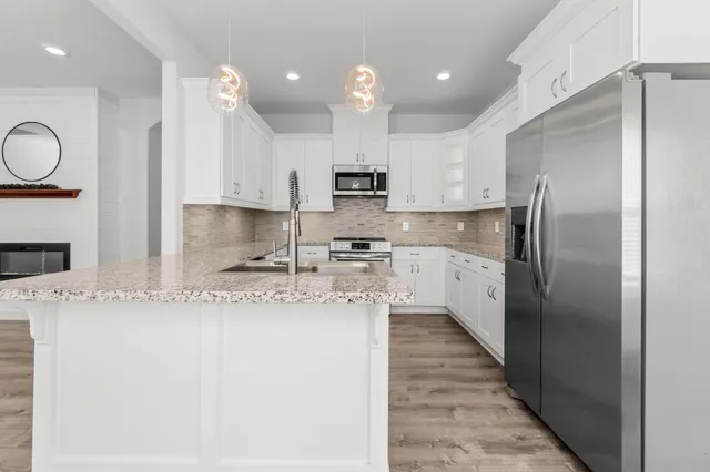 a kitchen with stainless steel appliances granite countertop a sink refrigerator and cabinets