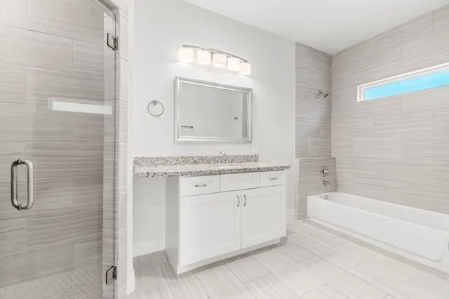 a bathroom with a granite countertop sink a toilet and shower