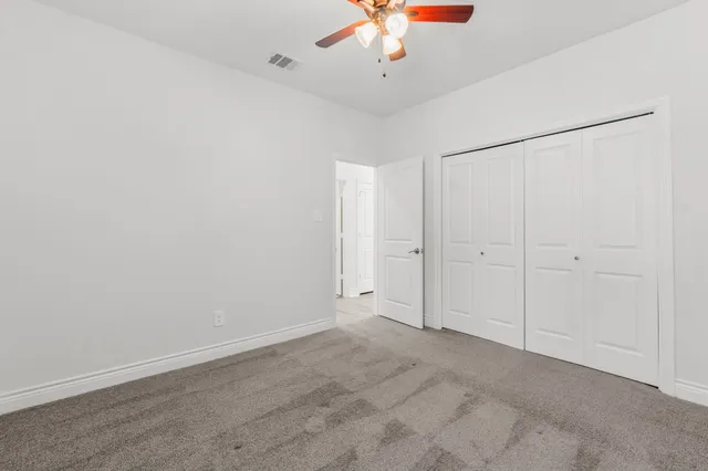 an empty room with a empty space and a ceiling fan