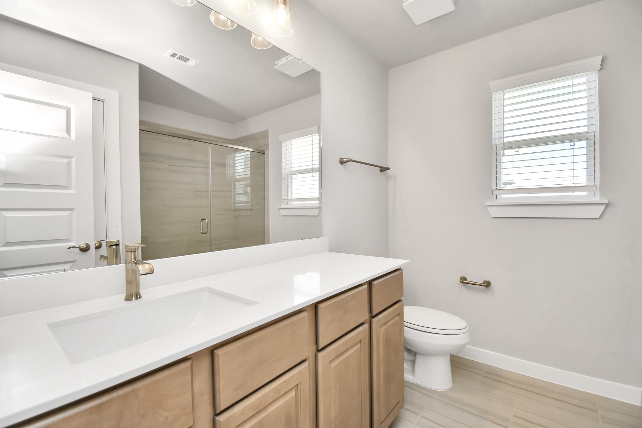 3106 Native Spg Drive Spring, TX 77373 - Photo 31 of 38 Secondary bath features tile flooring, a walk-in shower with tile surround, light stained wood cabinets, beautiful light countertop. Sample photo of completed home with similar floor plan. Actual colors and selections may vary.