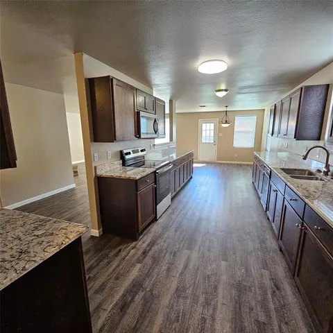 a spacious bathroom with a granite countertop double vanity sink and mirror