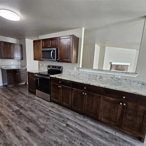 a view of a kitchen with sink and wooden floor