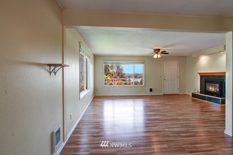 2106 Cedar Road Lake Stevens, WA 98258 - Photo 7 of 24 a view of a hallway with wooden floor and a fireplace